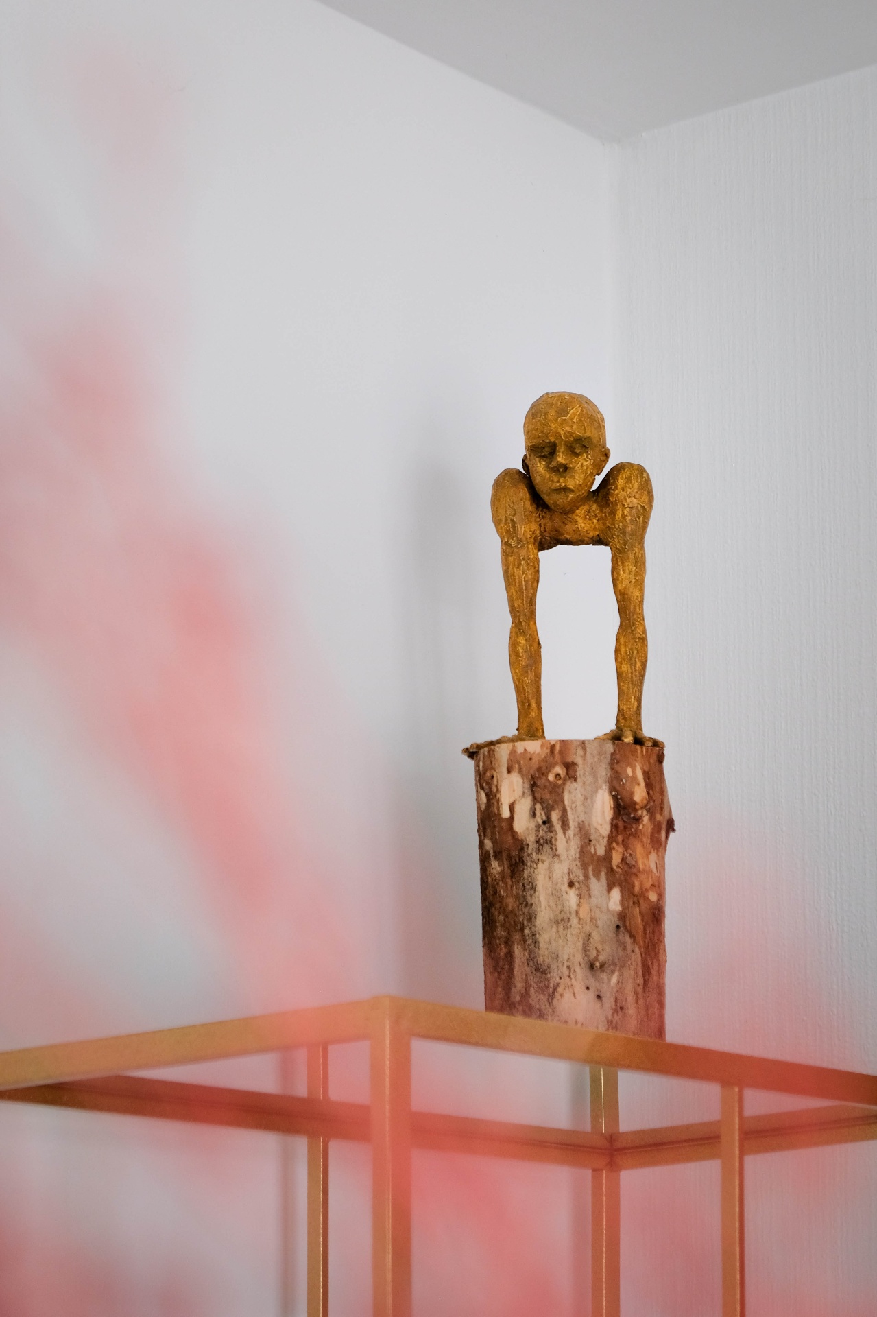 Gouden sculptuur op houten sokkel als artistiek detail