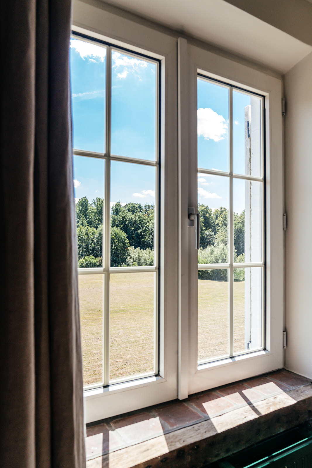 Uitzicht vanuit het landhuis op het park via hoge ramen