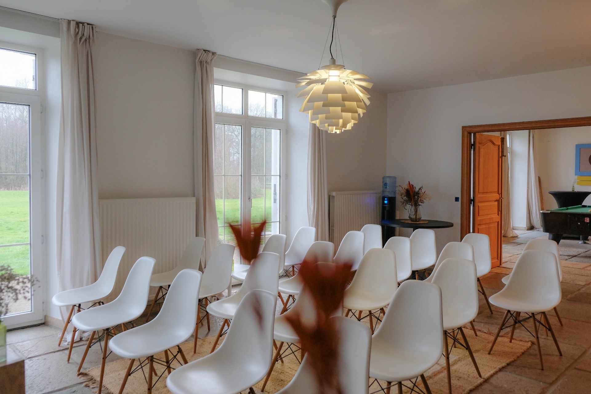 Binnenruimte opgesteld voor een presentatie met witte stoelen