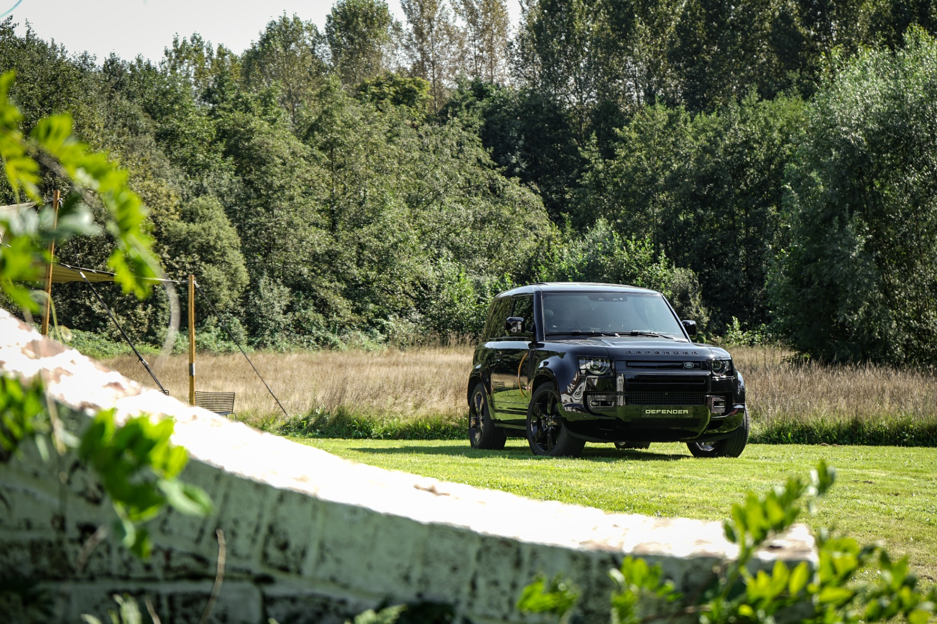 Zwarte Land Rover Defender in het weiland bij Villa Parkbos